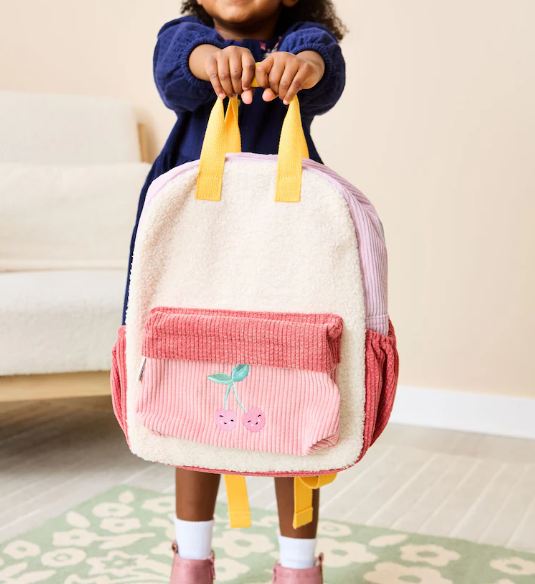Medium-sized children's teddy fleece backpack in a cherry blossom pink and cherry red color-block design